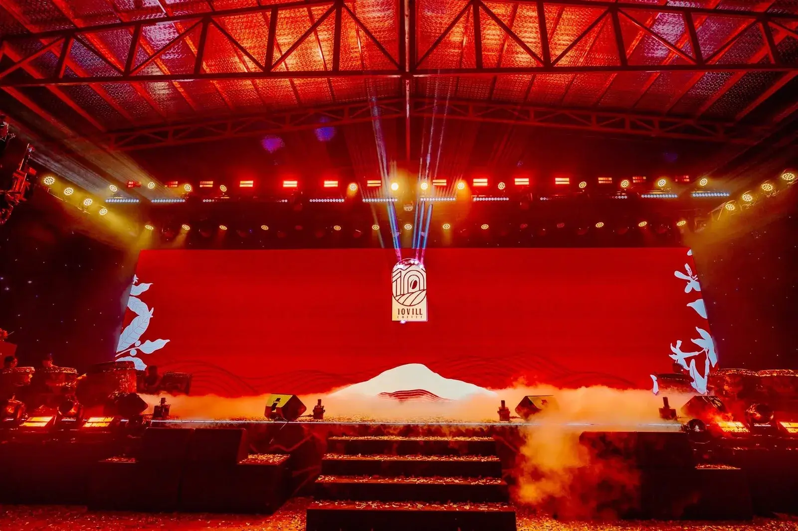 The arch mark revealed across the full thirty-metre stage in white light