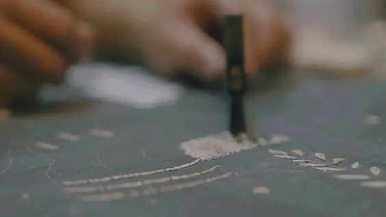 The artisan’s hands cutting inlay with a fine blade