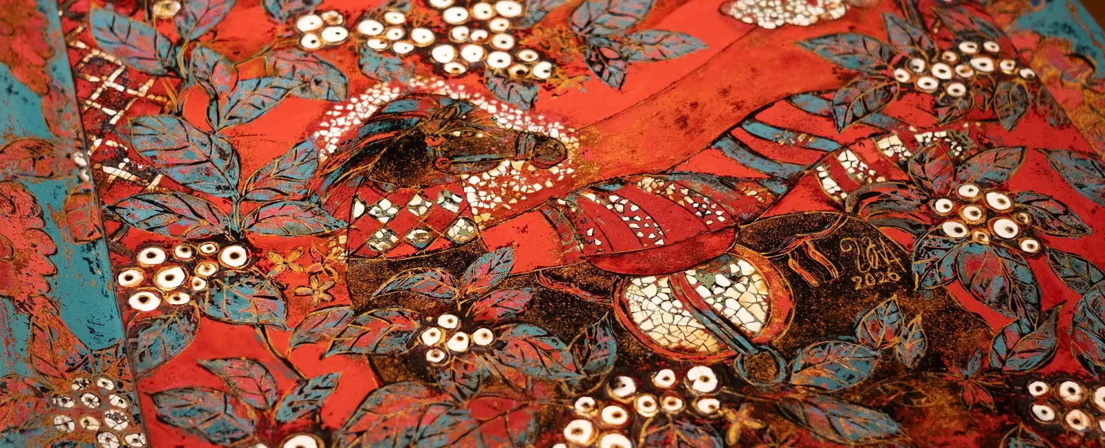 Macro of the lacquer surface — layered vermilion, gold leaf and inlaid shell
