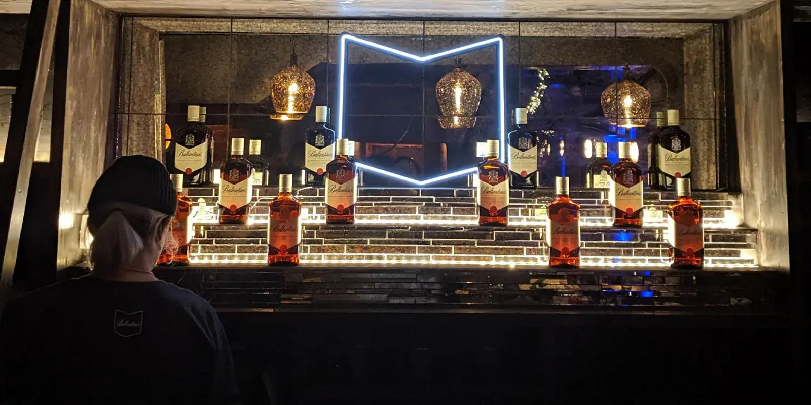 A bar interior with the chevron built at architectural scale in neon