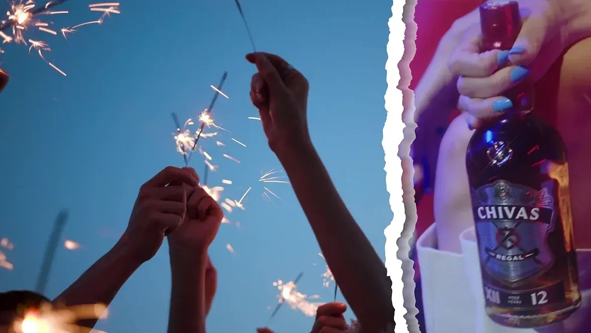 Footage still — friends raising glasses, the campaign super across the bottom