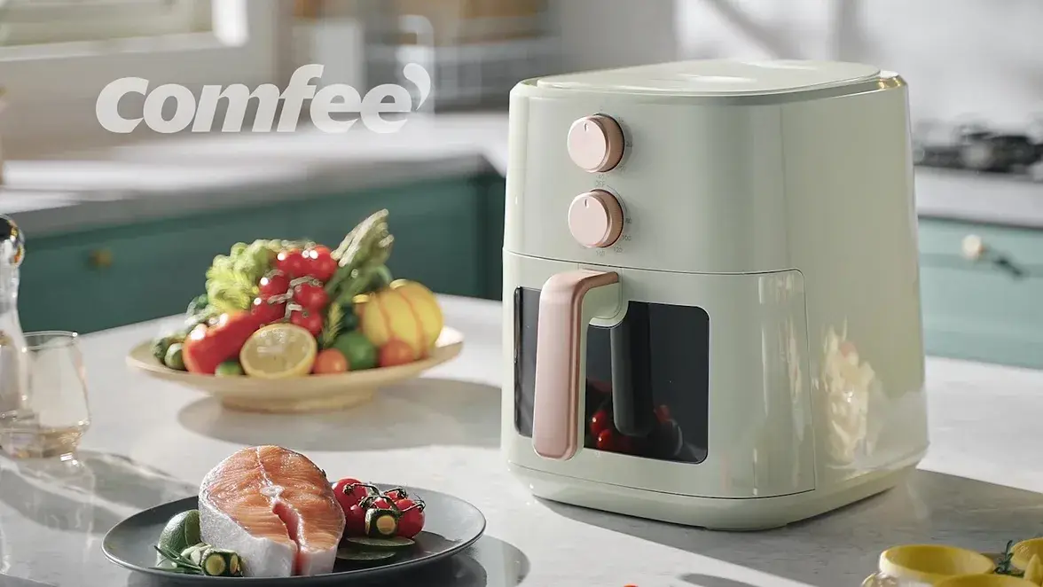The air fryer on a kitchen counter surrounded by prepared food