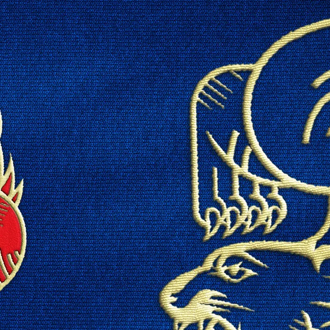 The embroidery at one-to-one — gold thread on deep blue