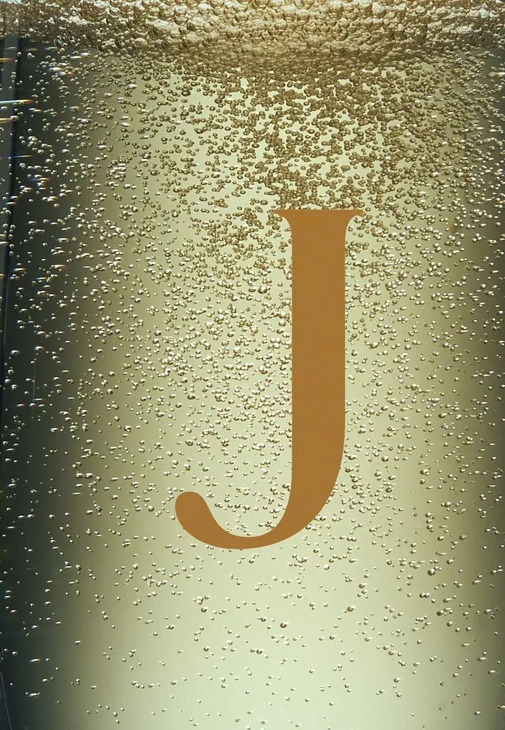 Detail — the gold J read through the wine in the glass
