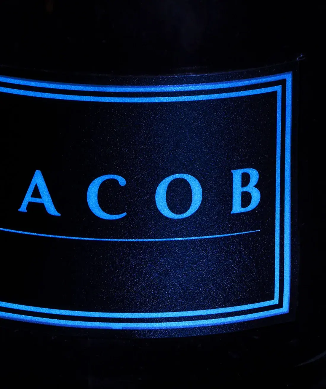 Detail — the cyan label outline lit from the edge