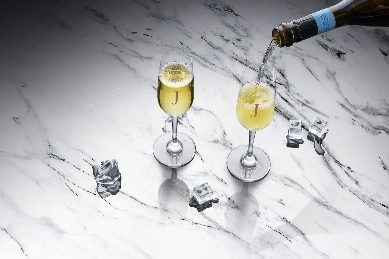 Top-down arrangement on marble, glasses and bottle from above