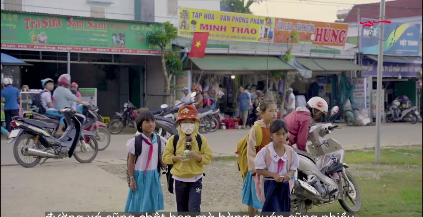 CSR film still — the road outside the school
