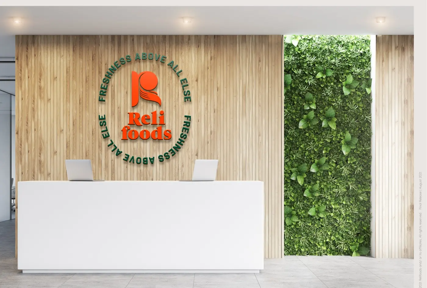 The reception counter — wordmark on the timber wall beside a planted green wall
