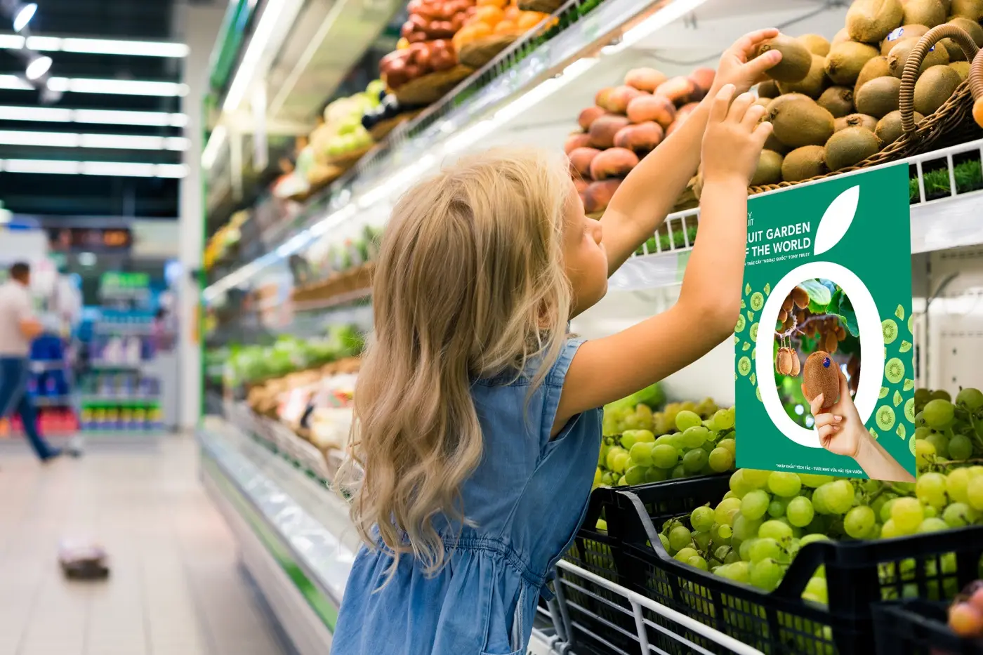 A child reaching for fruit on a supermarket shelf beside a branded shelf card